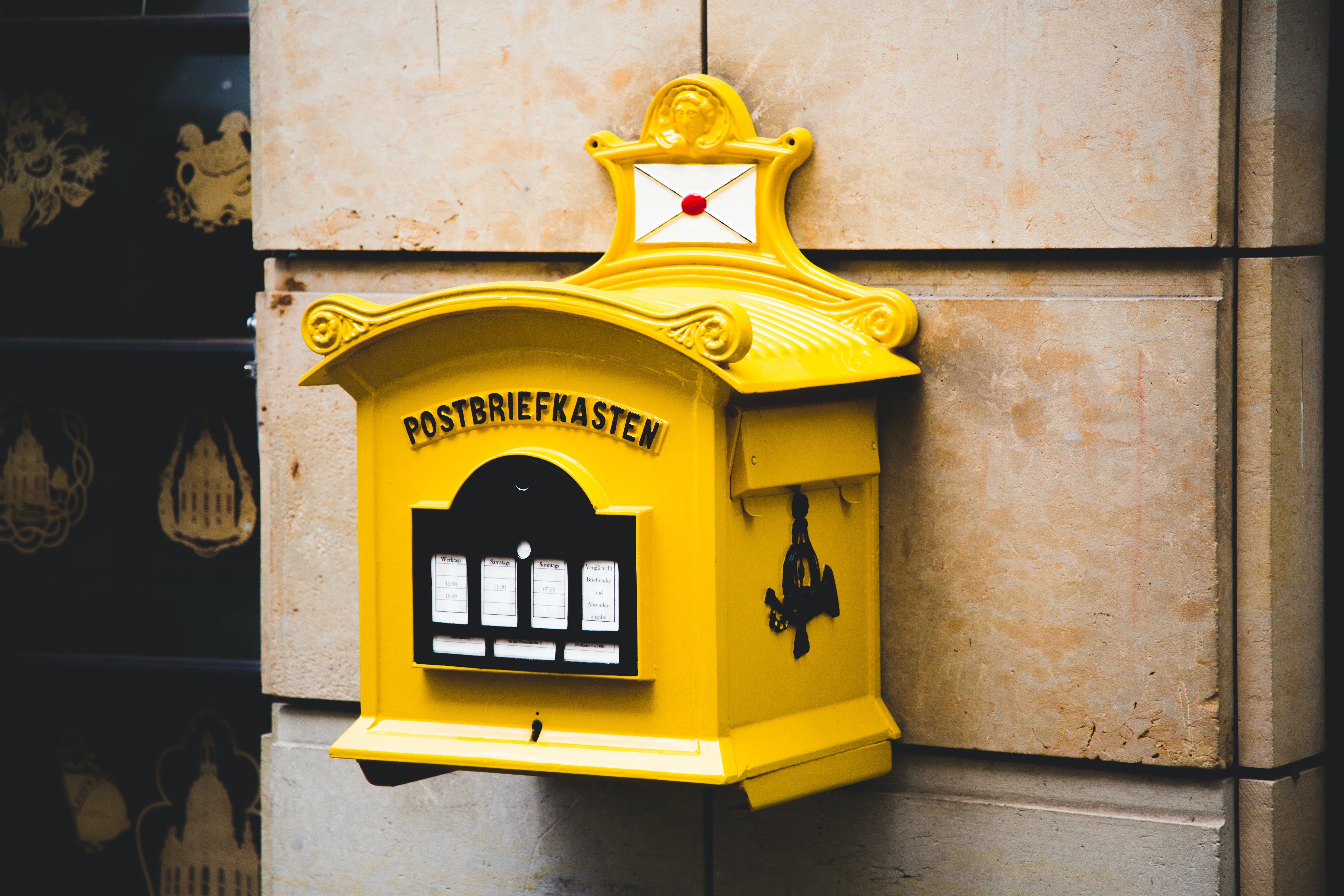 Yellow floating mailbox on brown concrete wall