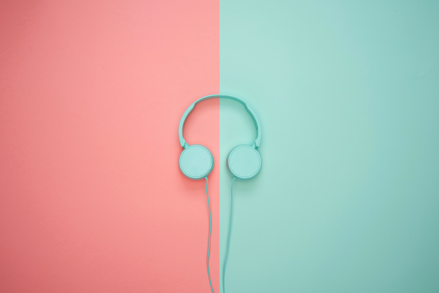 Turquoise headphones on a pink-turquoise background.